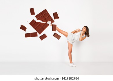 Fit Young Woman Kick Chocolate Bar, Diet Concept, Fighting  Sugar And Fast Food