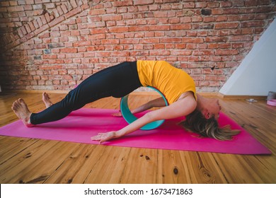 Fit Young Woman Practicing Yoga At Home With The Wheel, Yoga Equipment, Back Stretching, Back Pain