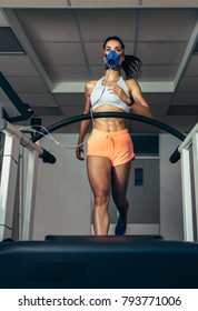 Fit Young Woman Running On Treadmill With A Mask. Athlete Examining Her Performance In Sports Science Lab.