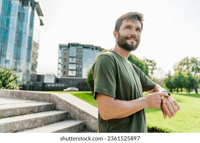 The fitness app uses a smartwatch. A runner doing a workout exercise jogging. The male coach is hardy.  A sporty man in sportswear is running. - Powered by Shutterstock