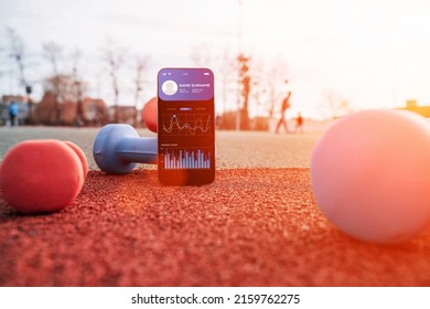 Fitness Application. Smartphone Screen With Sport Gym Or Fitness Health Mobile Application On Dumbbell Background. Online Fitness Program