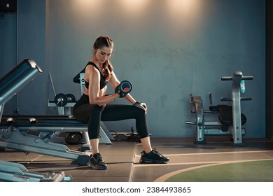 Fitness asian woman doing exercise and lifting dumbbells weights at sport gym. - Powered by Shutterstock