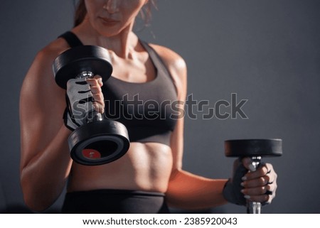 Fitness asian woman doing exercise and lifting dumbbells weights at sport gym.