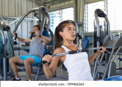 Fitness Asian Woman Working Out Shoulder Pull Down At Gym. Girl Strength Training Using Lat Pulldown Machine.