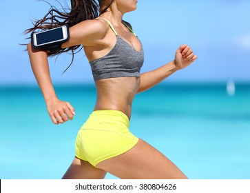 Fitness athlete woman running fast with speed wearing phone armband with touchscreen. Midsection crop showing muscular legs and thighs training glutes during intense cardio workout. - Powered by Shutterstock