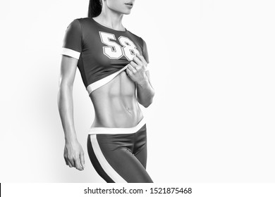 Fitness Athletic Young Woman Showing Her Well Trained Body, Six Pack, Perfect Abs, Shoulders, Biceps, Triceps And Chest, Deltoid Muscle Croped Black And White Shot On White Background