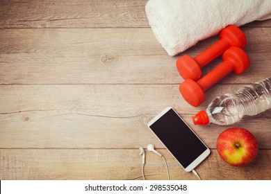 Fitness background with bottle of water, dumbbells and smartphone. View from above - Shutterstock ID 298535048