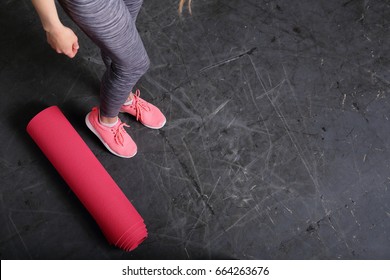 Fitness background, copy space, sport urban style, slim female legs, yoga mat, gray background - Powered by Shutterstock