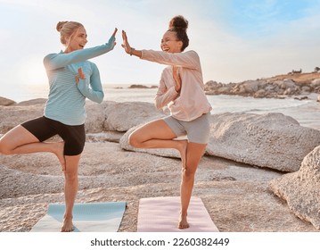 Fitness, beach and women doing a yoga exercise together for mind, body and spiritual wellness. High five, meditation and happy female friends celebrating doing a pilates workout by ocean for health. - Powered by Shutterstock