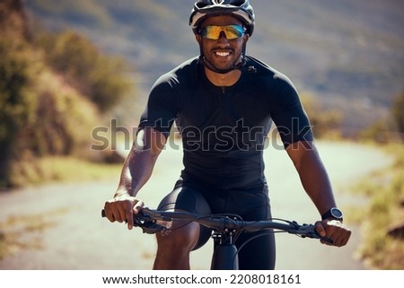 Fitness, bicycle and exercise man cycling outdoor in a street during summer with glasses and a helmet for safety. Happy athlete riding a bike to practice, workout or training for a race competition