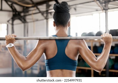 Fitness, black woman or bodybuilder with a barbell in training, workout or exercise for body goals. Back view, mindset or sports athlete weightlifting with strong biceps or focus at gym club studio - Powered by Shutterstock