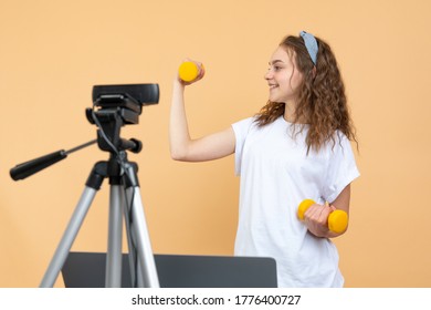 Fitness Blogger Makes A Workout Video At Home With Notebook And Web Cam, Biceps Training With Yellow Dumbbells