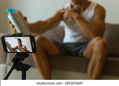 Fitness blogger is streaming or recording video for his subscribers during his home workout - Powered by Shutterstock