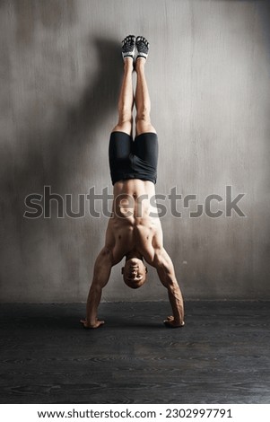 Fitness body, wall and man doing handstand for muscle workout, balance focus or health club exercise. Gym training, hand stand and strong person, athlete or sportsman doing push up challenge
