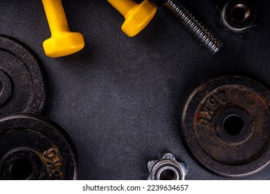 Fitness or bodybuilding background. Old hard iron dumbbells, small colorful dumbbells,  notepad with workout plan list. Back to gym concept, weight lifting sport flat lay top view copy space   - Powered by Shutterstock