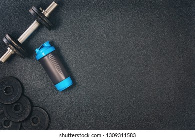 Fitness Or Bodybuilding Concept Background. Product Photograph Of Old Iron Dumbbells On Black Grey, Conrete Floor In The Gym. Photograph Taken From Above, Top View With Lots Of Copy Space