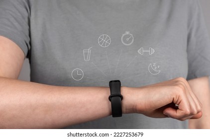 Fitness bracelet on hand, wrist of female athlete close up. Checking activity, functions on smart band, tracker. High quality photo - Shutterstock ID 2227253679
