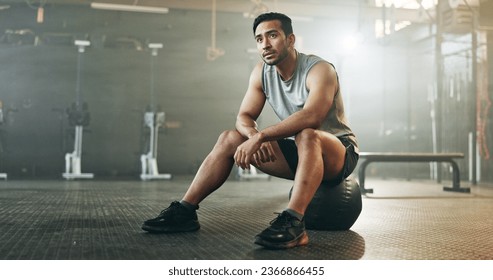 Fitness, breathing and sweating with a tired man in the gym, resting after an intense workout. Exercise, health and fatigue with a young athlete in recovery from training for sports or wellness - Powered by Shutterstock