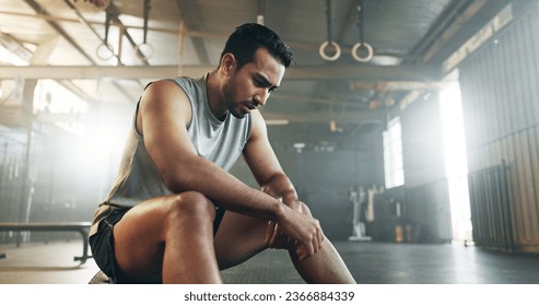 Fitness, breathing and sweating with a tired man in the gym, resting after an intense workout. Exercise, health and fatigue with a young athlete in recovery from training for sports or wellness - Powered by Shutterstock