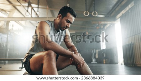 Fitness, breathing and sweating with a tired man in the gym, resting after an intense workout. Exercise, health and fatigue with a young athlete in recovery from training for sports or wellness