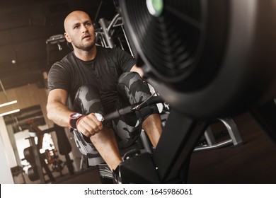 Fitness caucasian young adult man using rowing machine in the gym for fit training - Powered by Shutterstock