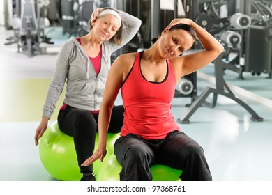 Fitness center senior woman with trainer stretching on swiss ball - Powered by Shutterstock