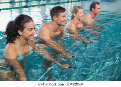 Fitness Class Doing Aqua Aerobics On Exercise Bikes In Swimming Pool At The Leisure Centre