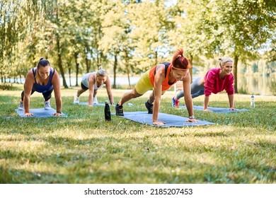 Fitness class group of women doing outdoor workout in park - Powered by Shutterstock