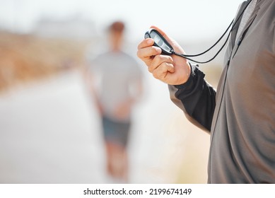 Fitness, Coach And Stopwatch Of Hands, Time And Runner Speed And Performance For Record Over Blurred Background. Hand Of Trainer In Motivation For Breaking Times Holding Digital Chronometer In Sports