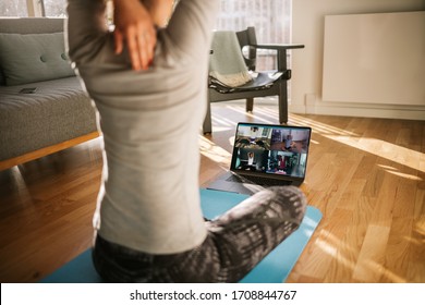 Fitness Coach Teaching Yoga Online To Group Of People. Yoga Trainer Demonstrating Yoga Poses To Students Via Video Conference.