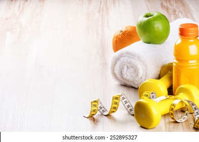 Fitness concept with dumbbells and fresh fruits 
