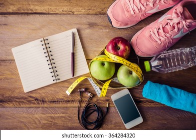 Fitness Concept With Exercise Equipment On Wooden Background.