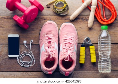 Fitness Concept With Exercise Equipment On Wooden Background