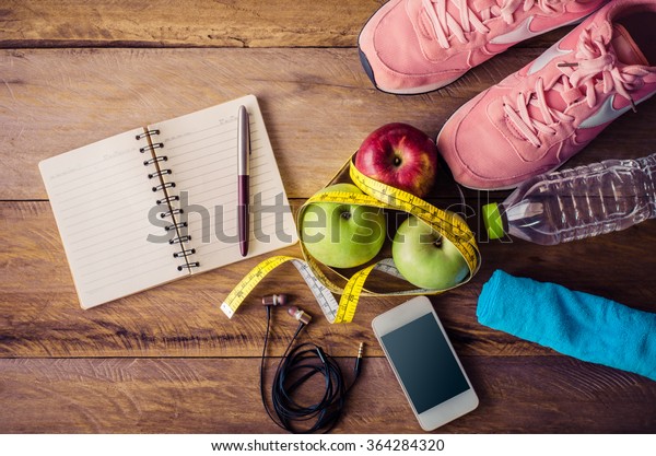 fitness concept with Exercise Equipment on\
wooden background.