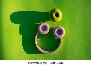 Fitness Concept , Headphones And Green Apple On Yoga Green Yoga Mat, Sunny Day, Top View 