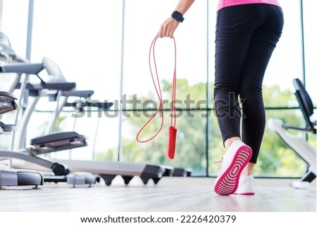 Fitness concept. Healthy lifestyle. Young slim woman jumping with skipping rope in gym.