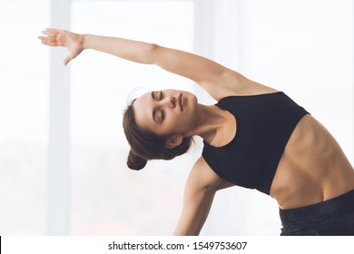 Fitness Concept. Relaxed Girl Streching Arms And Practicing Yoga At Home