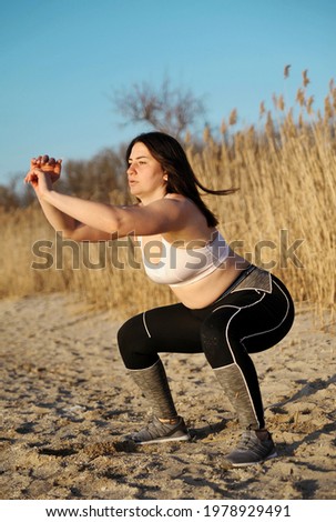 Fitness concept. Woman makes exercises outdoors.
