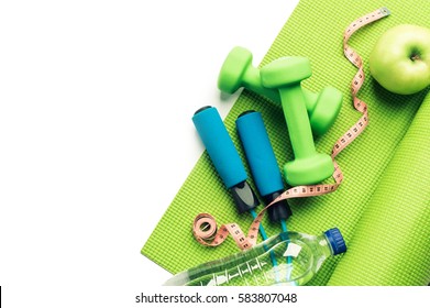 Fitness Concept - Yoga Mat, Apple, Dumbbells And Skipping Rope On The White Background