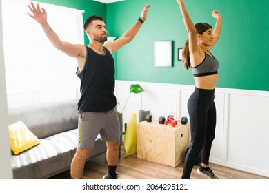 Fitness Couple. Active Woman And Man Doing A High Intensity Interval Training At Home And Exercising With Jumping Jacks