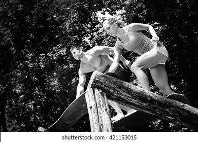 Fitness couple crossing fitness trial in park - Powered by Shutterstock