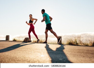 Fitness couple enjoying a run on the street. Athletes training for a marathon together. - Shutterstock ID 1808826166