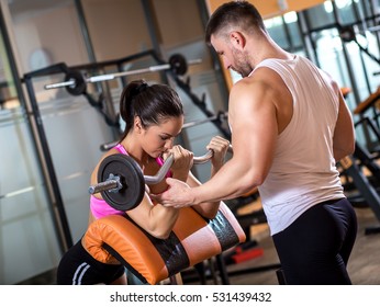 Fitness Couple Exercising In Gym With Barbell Weights.