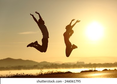 Fitness couple jumping happy at sunset with the sun in the background - Shutterstock ID 246061795