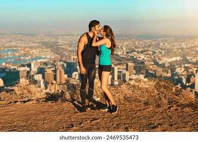 Fitness, couple and kiss on mountain outdoor with city view, exercise and workout together for healthcare or affection. Man, woman and bonding with adventure in summer for hiking, nature and cardio. - Powered by Shutterstock