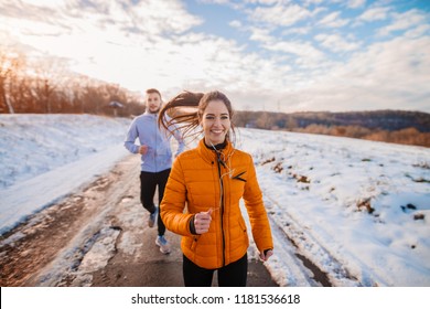 Fitness Couple Winter Morning Exercise At Snowy Mountain.