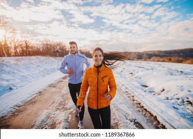 Fitness Couple Winter Morning Exercise At Snowy Mountain.