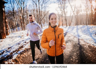 Fitness Couple Winter Morning Exercise At Snowy Mountain.