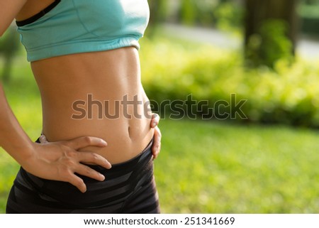Fitness and diet concept: cropped image of woman in sportswear with perfect abs