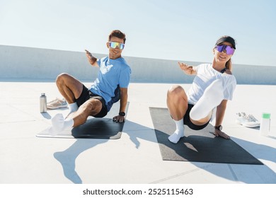 Fitness Enthusiasts Exercising Outdoors on a Sunny Day, Performing Core Workouts on Mats in a Bright Urban Environment - Powered by Shutterstock